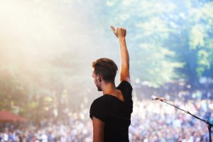 A performer standing on stage facing the crowd with his hand in the airhttp://195.154.178.81/DATA/i_collage/pi/shoots/782675.jpg
