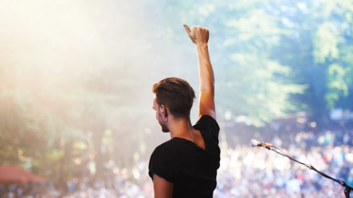 A performer standing on stage facing the crowd with his hand in the airhttp://195.154.178.81/DATA/i_collage/pi/shoots/782675.jpg