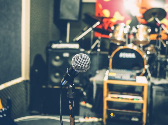 Selective focus on microphone with blurry music studio background, vintage style