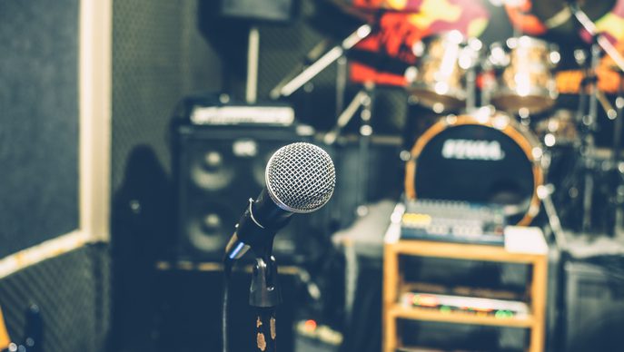 Selective focus on microphone with blurry music studio background, vintage style